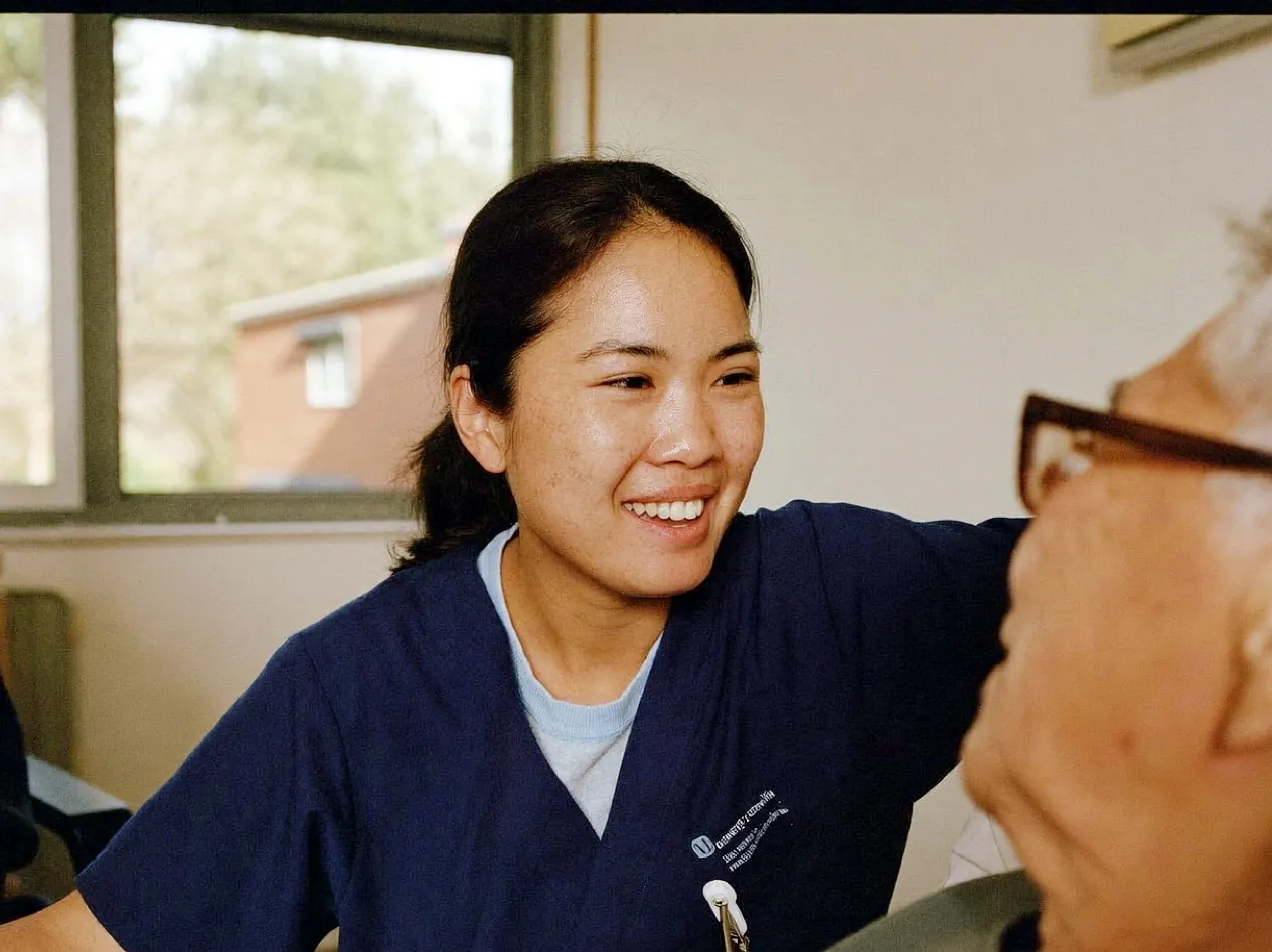 Filipina nurse with an older patient on a hospital ward